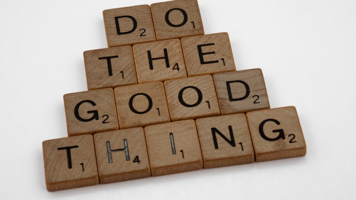 Wooden tiles arranged to spell 'Do The Good Thing,' promoting positive action.